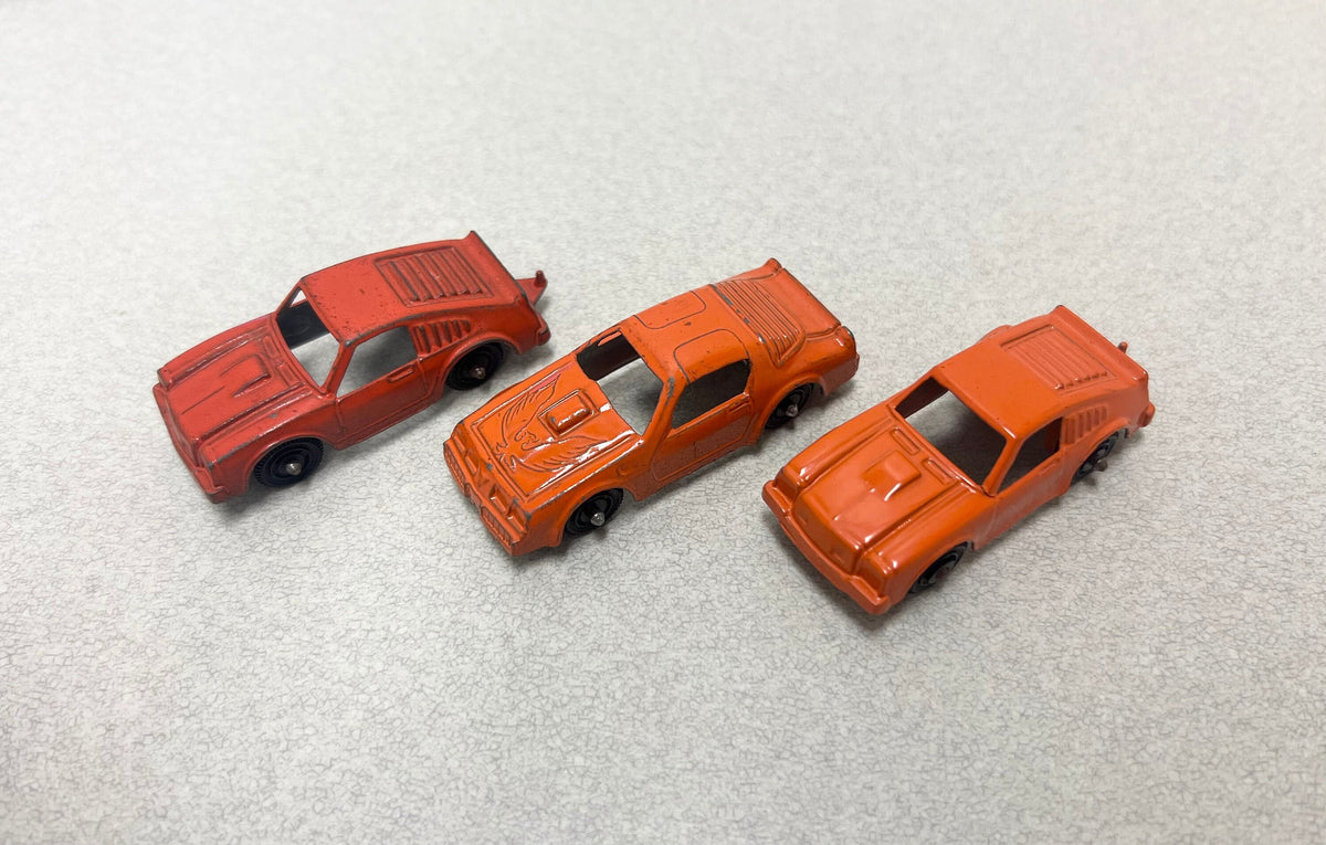 Tootsie Toy Set Of Three- Orange Pontiac Firebird And 2 Ford Mustangs Sold as a set.